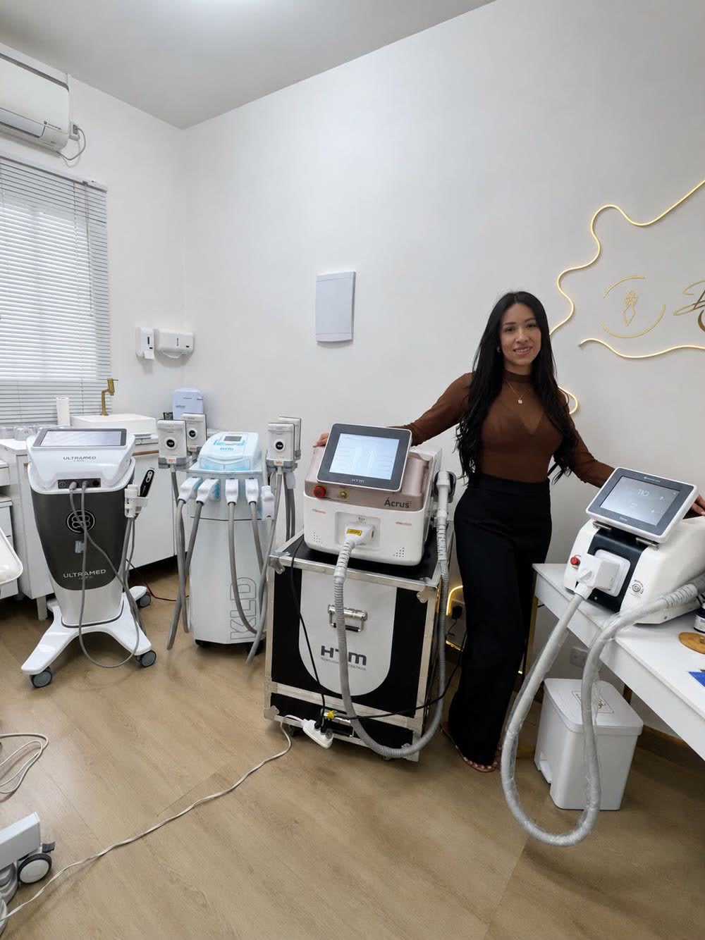 Dra. Viviane Luizi ao lado dos equipamentos de laser e tecnologia da clínica